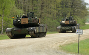 Twee Europese tanks rijden op een bospad