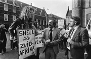 Kamerleden Ter Beek en Jan Nico Scholten bij een demonstratie op het Binnenhof, waar iemand een bord met &#34;Shell uit Zuid-Afrika&#34; omhoog houdt.
