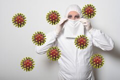Vrouw met beschermend pak en coronavirussen